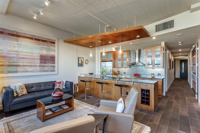 living room with dark wood-style floors, baseboards, visible vents, and track lighting