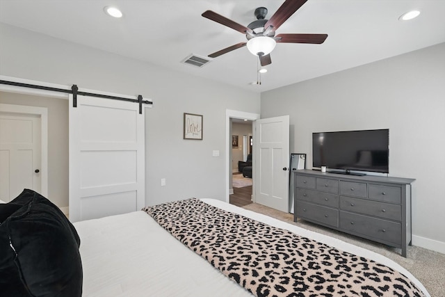 bedroom featuring recessed lighting, visible vents, a barn door, a ceiling fan, and light carpet