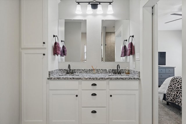 full bathroom featuring double vanity, ceiling fan, connected bathroom, and a sink