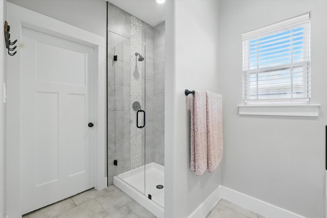 bathroom featuring a stall shower, baseboards, and tile patterned floors