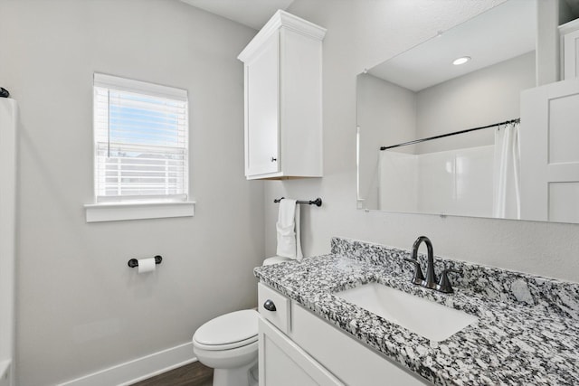 bathroom with toilet, vanity, wood finished floors, a shower with curtain, and baseboards