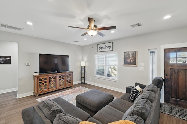 living area featuring plenty of natural light, visible vents, and wood finished floors