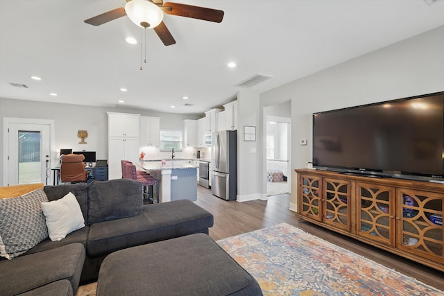 living room with recessed lighting, visible vents, ceiling fan, light wood-type flooring, and baseboards