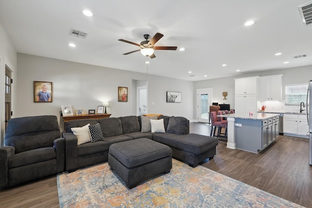 living area with dark wood-type flooring, recessed lighting, and visible vents