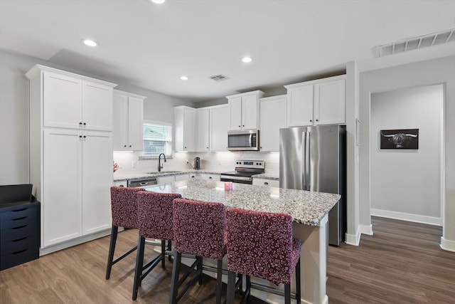 kitchen with visible vents, stainless steel appliances, a sink, and wood finished floors