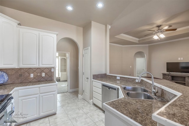 kitchen featuring arched walkways, range with electric stovetop, a sink, stainless steel dishwasher, and a tray ceiling