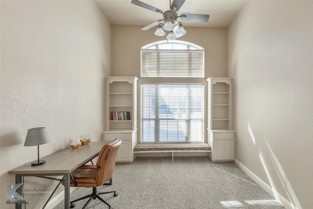 office space featuring light carpet, plenty of natural light, baseboards, and ceiling fan