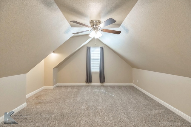 bonus room with carpet floors, baseboards, vaulted ceiling, and a textured ceiling