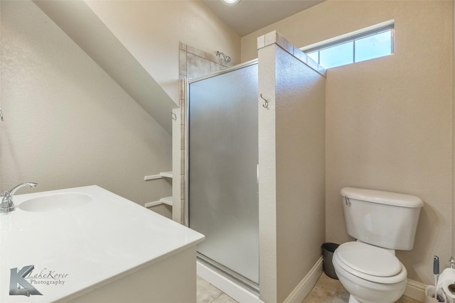 bathroom featuring a stall shower, baseboards, a sink, and toilet