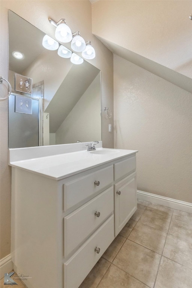 bathroom with vanity, baseboards, and tile patterned floors