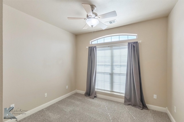 unfurnished room featuring baseboards, visible vents, a ceiling fan, and light colored carpet