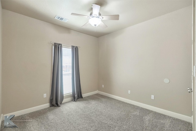 carpeted empty room featuring ceiling fan, visible vents, and baseboards