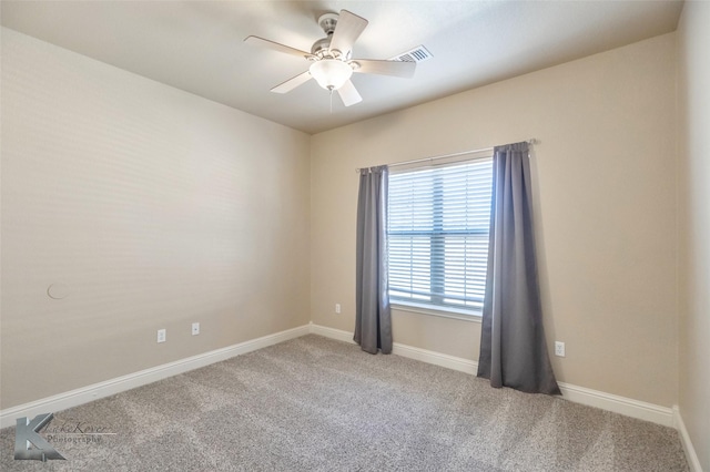 carpeted spare room featuring baseboards, visible vents, and a ceiling fan