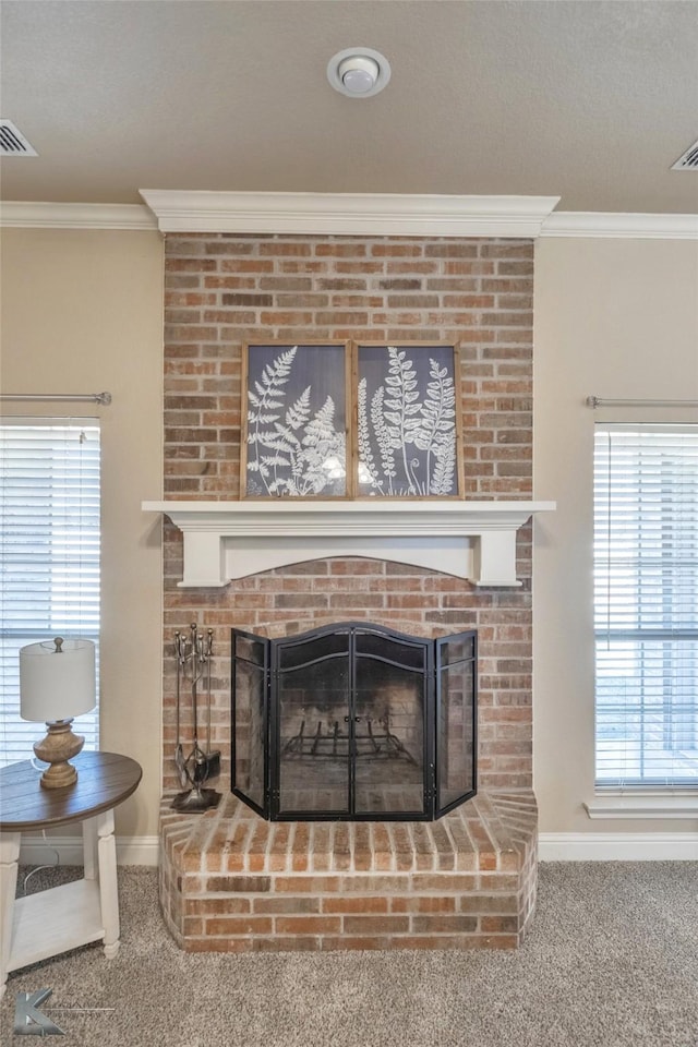 interior details featuring carpet floors, a fireplace, crown molding, visible vents, and baseboards