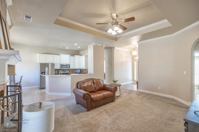 living area with arched walkways, a fireplace, a raised ceiling, visible vents, and ornamental molding