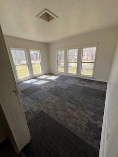 unfurnished room featuring dark colored carpet