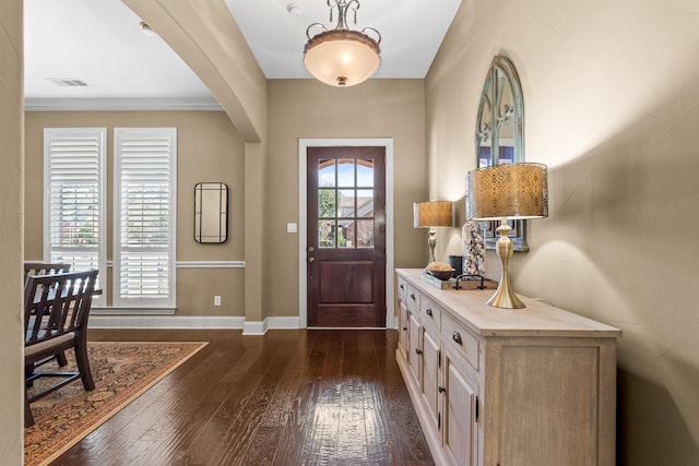 foyer with dark wood-style floors, arched walkways, visible vents, and a healthy amount of sunlight