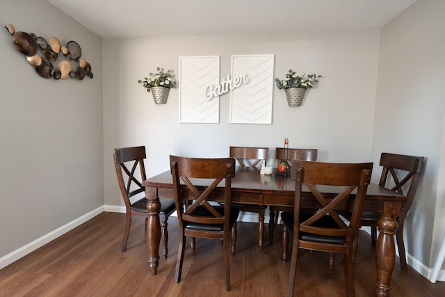 dining space with baseboards and wood finished floors