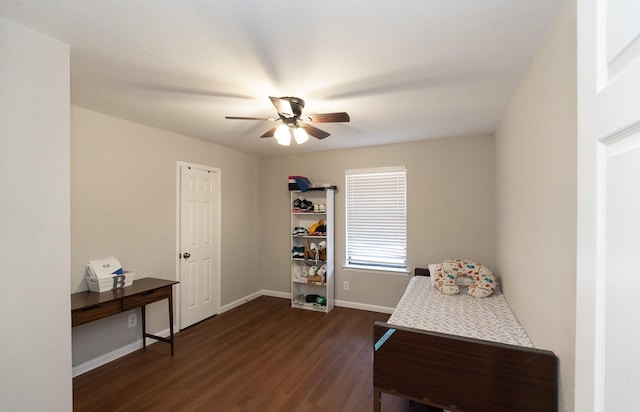 interior space with a ceiling fan, dark wood-style flooring, and baseboards