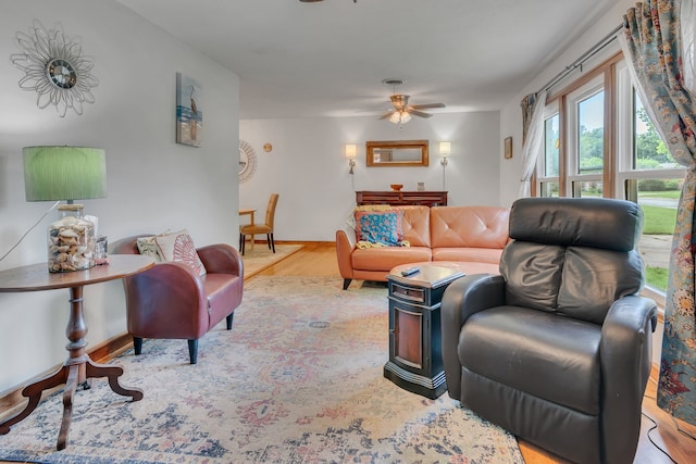 living area with ceiling fan, baseboards, and wood finished floors