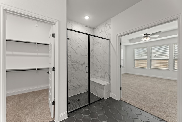 full bathroom featuring a shower stall, a walk in closet, and baseboards