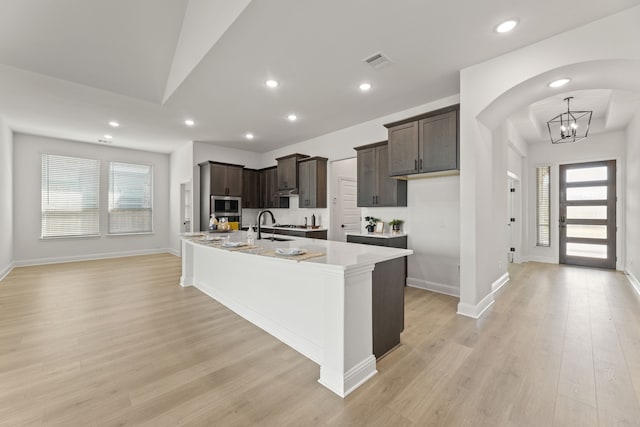 kitchen with dark brown cabinetry, visible vents, stainless steel appliances, and a sink