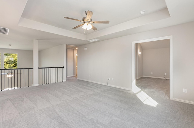 unfurnished room featuring carpet, visible vents, and a raised ceiling