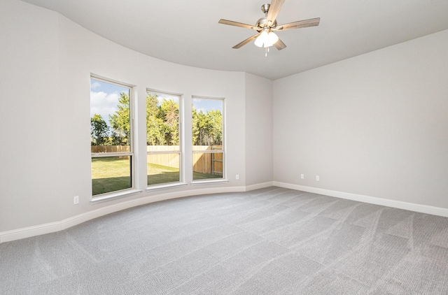 empty room featuring ceiling fan, carpet floors, and baseboards