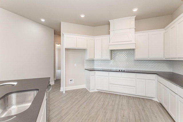 kitchen featuring dark countertops, a sink, and light wood-style flooring