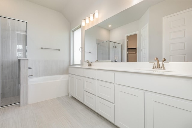 bathroom featuring double vanity, a stall shower, a sink, vaulted ceiling, and a bath