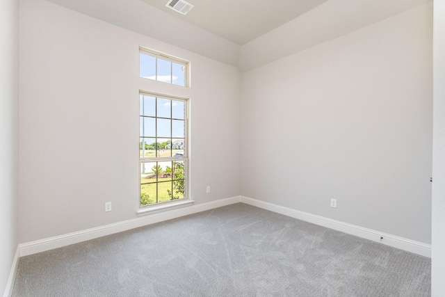 carpeted spare room featuring visible vents and baseboards