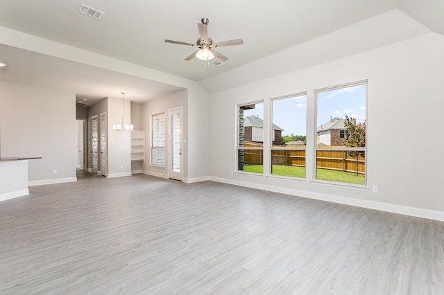 unfurnished living room with lofted ceiling, baseboards, visible vents, and wood finished floors