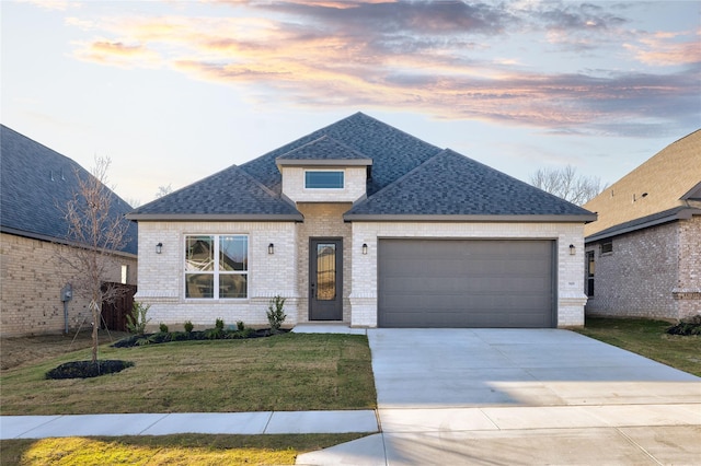 view of front facade with a garage, a front yard, concrete driveway, and brick siding