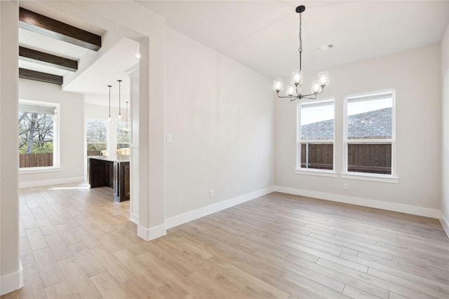 unfurnished dining area with baseboards, light wood-style flooring, beam ceiling, and a notable chandelier