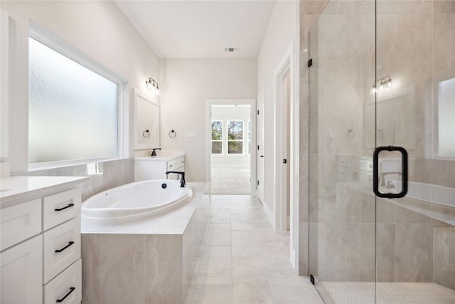 bathroom with a bath, two vanities, a shower stall, and visible vents