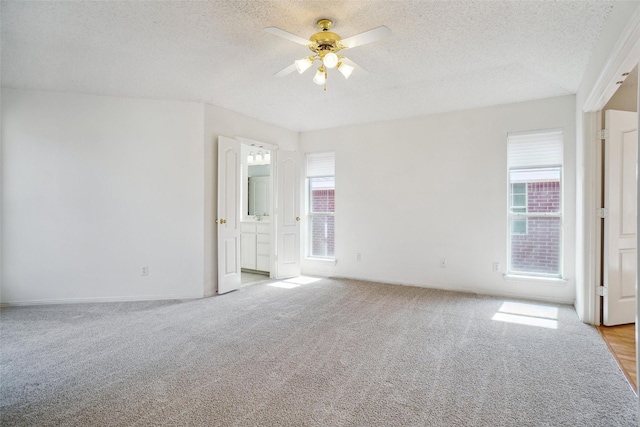 unfurnished bedroom featuring a textured ceiling, a ceiling fan, carpet flooring, and ensuite bathroom