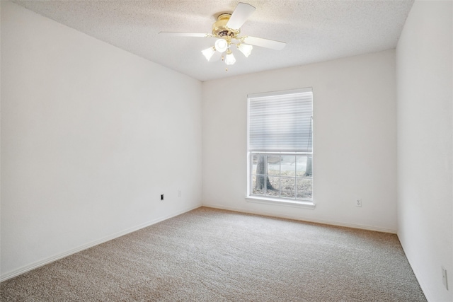 carpeted empty room featuring a textured ceiling, baseboards, and a ceiling fan