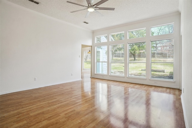 spare room featuring a ceiling fan, crown molding, a textured ceiling, and light wood finished floors