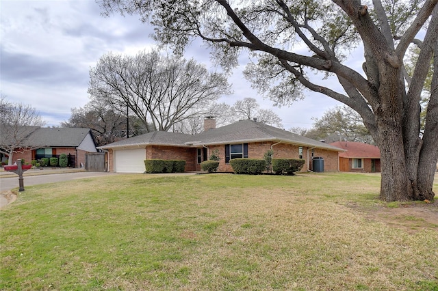 single story home with brick siding, a chimney, a front yard, a garage, and driveway