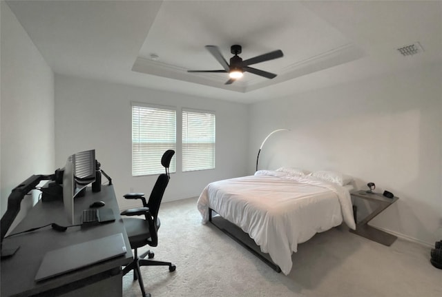 bedroom with light colored carpet, a ceiling fan, baseboards, visible vents, and a raised ceiling