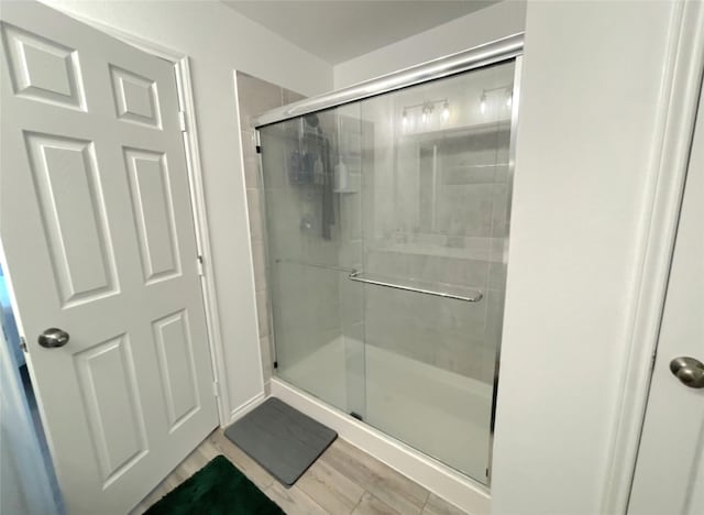 bathroom featuring a stall shower and wood finished floors