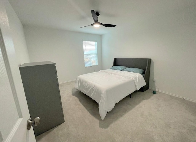 bedroom featuring baseboards, a ceiling fan, and light colored carpet