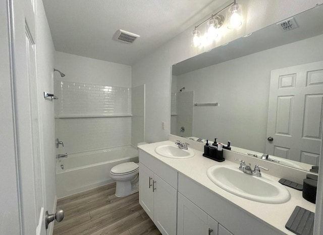 full bathroom featuring toilet, bathtub / shower combination, a sink, and wood finished floors