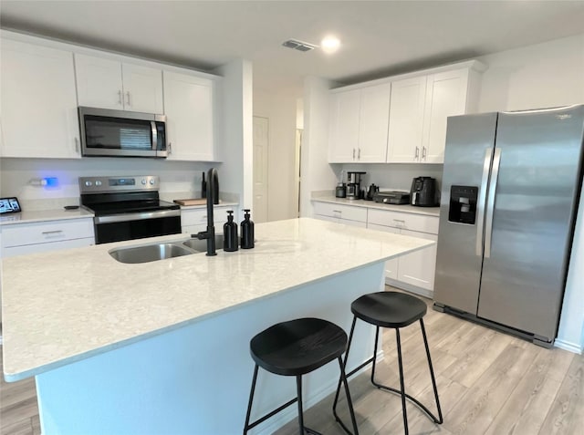 kitchen with light wood-style floors, stainless steel appliances, and light countertops