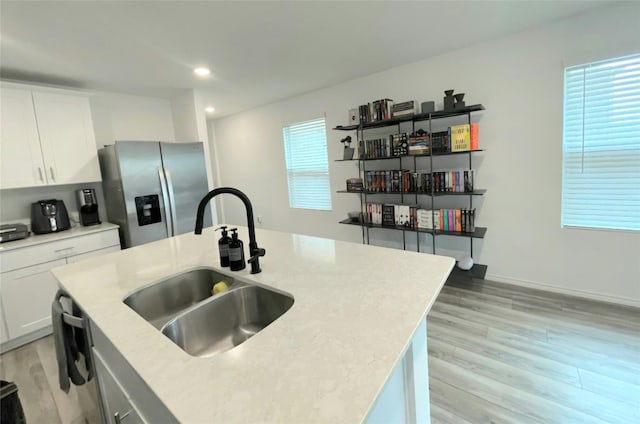 kitchen with a wealth of natural light, stainless steel fridge, light wood-style flooring, and a sink