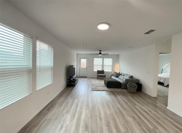 unfurnished living room with light wood-style floors, visible vents, baseboards, and a ceiling fan