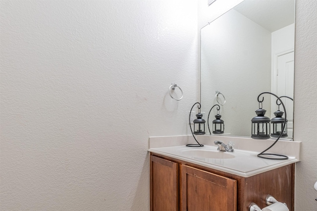 bathroom with a textured wall and vanity