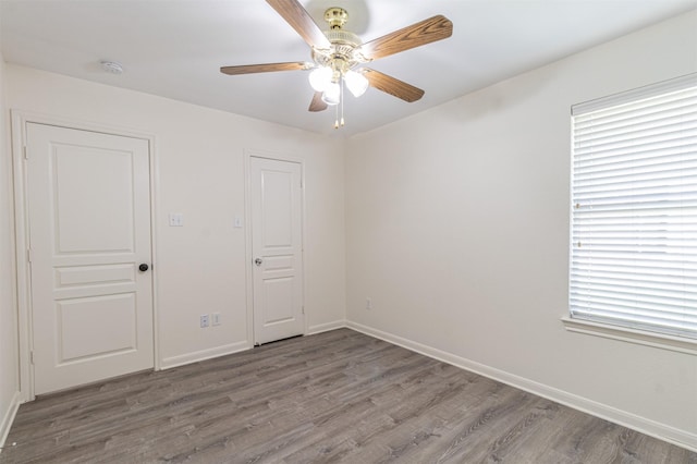 spare room with a ceiling fan, baseboards, and wood finished floors