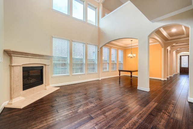 unfurnished living room featuring dark wood-type flooring, crown molding, baseboards, and a premium fireplace