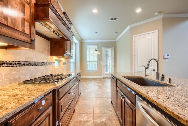 kitchen with decorative backsplash, light stone countertops, stainless steel appliances, crown molding, and a sink